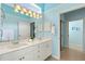 Well-lit bathroom features a double vanity and leads to the walk-in closet at 1610 Monarch Dr # 1610, Venice, FL 34293