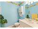 Bright and airy bathroom with light blue walls and floral accents at 1610 Monarch Dr # 1610, Venice, FL 34293
