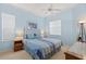 Light blue bedroom with a white bed, ceiling fan, and bright, natural light from two windows at 1610 Monarch Dr # 1610, Venice, FL 34293