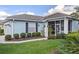 Charming blue single-story home with a well-manicured lawn, tile roof, and inviting screened entrance at 1610 Monarch Dr # 1610, Venice, FL 34293