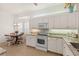 Well-lit kitchen with granite countertops, white cabinetry, stainless appliances, and a cozy breakfast nook at 1610 Monarch Dr # 1610, Venice, FL 34293