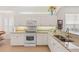 Bright kitchen features granite countertops, white cabinets, and modern appliances, creating an efficient cooking space at 1610 Monarch Dr # 1610, Venice, FL 34293