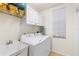 Functional laundry room with a white washer, dryer, utility sink, and storage shelves at 1610 Monarch Dr # 1610, Venice, FL 34293