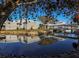 Scenic view of a peaceful pond reflecting community buildings, enhanced by lush trees and colorful foliage at 1610 Monarch Dr # 1610, Venice, FL 34293