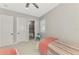 Bright bedroom with a ceiling fan, a colorful chair, and an ensuite bathroom featuring tile floors at 18135 Home Run Dr, Venice, FL 34293