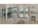 Elegant dining area featuring a glass table, modern chandelier, and seamless access to the screened pool area at 18135 Home Run Dr, Venice, FL 34293