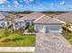 Inviting single-Gathering home featuring well-maintained landscaping, paver driveway, and an attached two-car garage at 18135 Home Run Dr, Venice, FL 34293