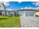 Lovely exterior view of home, highlighting the well-kept lawn, detailed stonework, and brick driveway at 18135 Home Run Dr, Venice, FL 34293