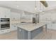 Modern kitchen featuring white cabinets, a center island, and stainless steel appliances at 18135 Home Run Dr, Venice, FL 34293