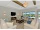 Comfortable living room with a large screen TV, neutral furniture, and a view of the pool at 18135 Home Run Dr, Venice, FL 34293