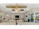 Bright living room with modern decor, sliding glass doors to the pool area, and a large television at 18135 Home Run Dr, Venice, FL 34293
