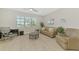 Bright living room features tile flooring, neutral paint, and a ceiling fan at 18135 Home Run Dr, Venice, FL 34293