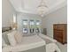 Peaceful main bedroom offering access to the pool area, complemented by a decorative chandelier and light-filled windows at 18135 Home Run Dr, Venice, FL 34293