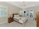 Serene main bedroom with a tray ceiling, elegant chandelier, and private access to the outdoor pool area at 18135 Home Run Dr, Venice, FL 34293