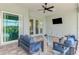 Covered patio with outdoor seating, a ceiling fan, and views of the surrounding landscape at 18135 Home Run Dr, Venice, FL 34293