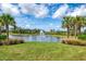 Scenic pond with a fountain surrounded by lush green grass and mature palm trees at 18135 Home Run Dr, Venice, FL 34293