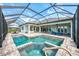 A gorgeous screened-in pool features a spa and outdoor seating at 18135 Home Run Dr, Venice, FL 34293