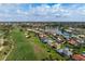 Stunning aerial view of home nestled on a golf course with pond views, surrounded by mature landscaping at 1915 Pebble Beach Ct, Venice, FL 34293