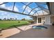 Enclosed back patio featuring a tranquil hot tub and stunning views of a well-maintained golf course at 1915 Pebble Beach Ct, Venice, FL 34293