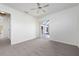 Sunlit bedroom with neutral carpet, ceiling fan, and sliding glass doors at 1915 Pebble Beach Ct, Venice, FL 34293