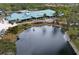 Scenic view of the community clubhouse, pond, and meticulously maintained grounds at 1915 Pebble Beach Ct, Venice, FL 34293