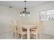 Bright dining room with a modern chandelier and a six-piece wood dining set at 1915 Pebble Beach Ct, Venice, FL 34293