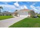 Well-maintained home with a spacious driveway, two-car garage, and beautifully landscaped front yard at 1915 Pebble Beach Ct, Venice, FL 34293