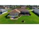 Aerial view of the back of house with a patio, green lawn, and well-manicured landscaping at 1915 Pebble Beach Ct, Venice, FL 34293