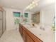 Bright bathroom featuring a double sink vanity, framed art, and a glass-enclosed shower at 19248 Isadora St, Venice, FL 34293