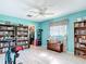 Bedroom with aqua walls, wood-look floors, a ceiling fan, and built-in bookshelves at 2 Windsor Dr, Englewood, FL 34223