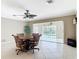 Lovely dining area with sliding glass doors to the pool area, complemented by tile flooring and a stylish ceiling fan at 2 Windsor Dr, Englewood, FL 34223