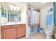 Well-lit bathroom with vanity and storage, tile flooring, shower with curtain, and decorative towels at 20181 Ragazza Cir # 101, Venice, FL 34293