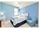 Light blue bedroom with queen bed, ceiling fan, and white furniture at 20181 Ragazza Cir # 101, Venice, FL 34293