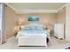 Well-lit bedroom with beach-themed artwork over the bed and a white storage bench at 20181 Ragazza Cir # 101, Venice, FL 34293