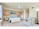 Bright bedroom with neutral walls, a ceiling fan, and a comfy chair and ottoman with seaside decor at 20181 Ragazza Cir # 101, Venice, FL 34293