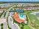 Aerial showing a community pool, clubhouse, tennis courts, a lake and tree lined streets at 20420 Symphony Pl, Venice, FL 34293