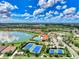 Aerial view featuring tennis courts, a community pool, clubhouse, and lake in the neighborhood at 20420 Symphony Pl, Venice, FL 34293