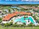 Aerial view featuring a large pool, hot tub, clubhouse, and lounge area within a gated community at 20420 Symphony Pl, Venice, FL 34293