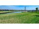 Lush green backyard with a serene pond view and a fence for privacy at 20420 Symphony Pl, Venice, FL 34293