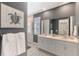Bathroom featuring double vanity, a large mirror, shower with glass door, and a turtle art piece at 20420 Symphony Pl, Venice, FL 34293