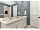Bathroom featuring double vanity with white cabinets and a large mirror at 20420 Symphony Pl, Venice, FL 34293