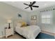 Comfortable bedroom featuring a ceiling fan, bed with plush pillows, and bright window at 20420 Symphony Pl, Venice, FL 34293