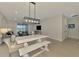The dining area features a large white table with seating and modern lighting, flowing into the living room at 20420 Symphony Pl, Venice, FL 34293