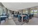 Spacious dining area featuring tables and chairs, complemented by large windows and stylish decor at 20420 Symphony Pl, Venice, FL 34293