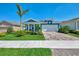 Charming, light blue single-Gathering home featuring a well-manicured lawn and paver driveway at 20420 Symphony Pl, Venice, FL 34293