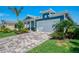 Beautiful light blue home with a paver driveway and vibrant landscaping at 20420 Symphony Pl, Venice, FL 34293