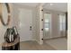 Bright foyer with luxury vinyl floors, entry door, and a view into the sunlit living room at 20420 Symphony Pl, Venice, FL 34293