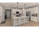Bright kitchen features white cabinets, quartz countertops, stainless steel appliances, and an island with pendant lighting at 20420 Symphony Pl, Venice, FL 34293