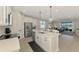 Open concept kitchen flows into the living area, featuring an island with seating and modern appliances at 20420 Symphony Pl, Venice, FL 34293