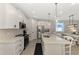 Bright kitchen with an island, white cabinets, stainless steel appliances, and an adjacent dining area at 20420 Symphony Pl, Venice, FL 34293